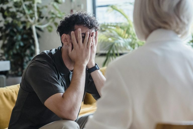 Man seeking support in therapy, expressing emotions during an indoor counseling session.
